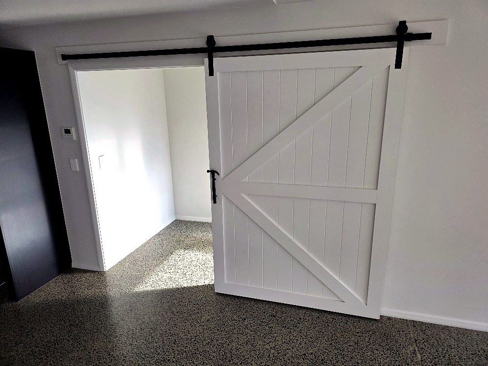 White cavity barn door on a black track
