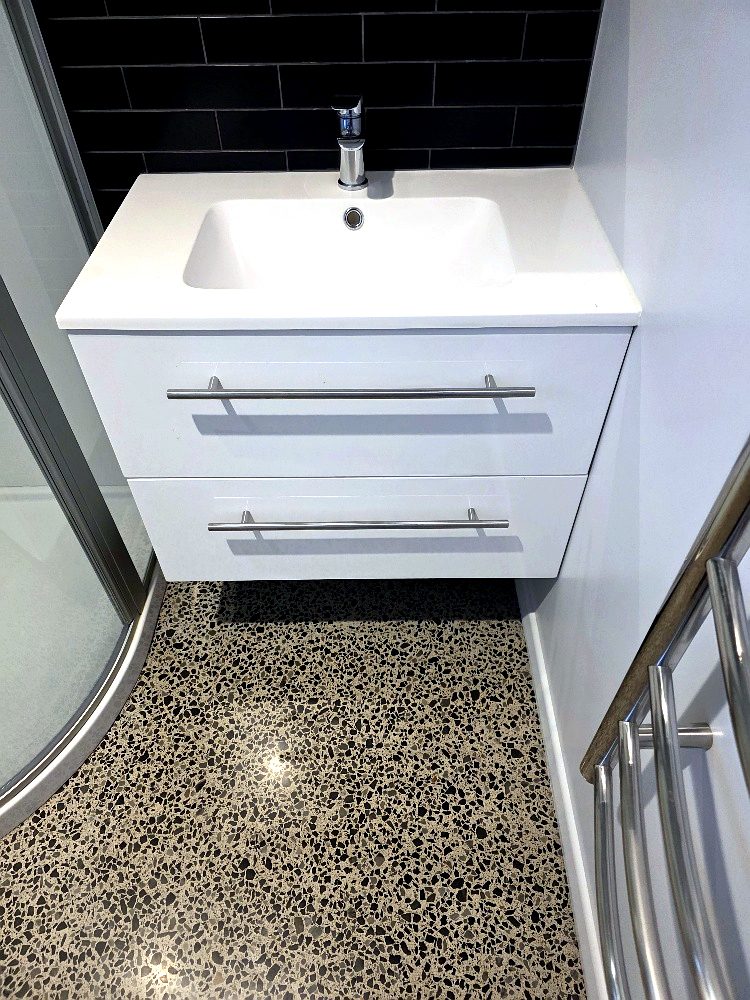 Wall-hung vanity with black tiled splashback