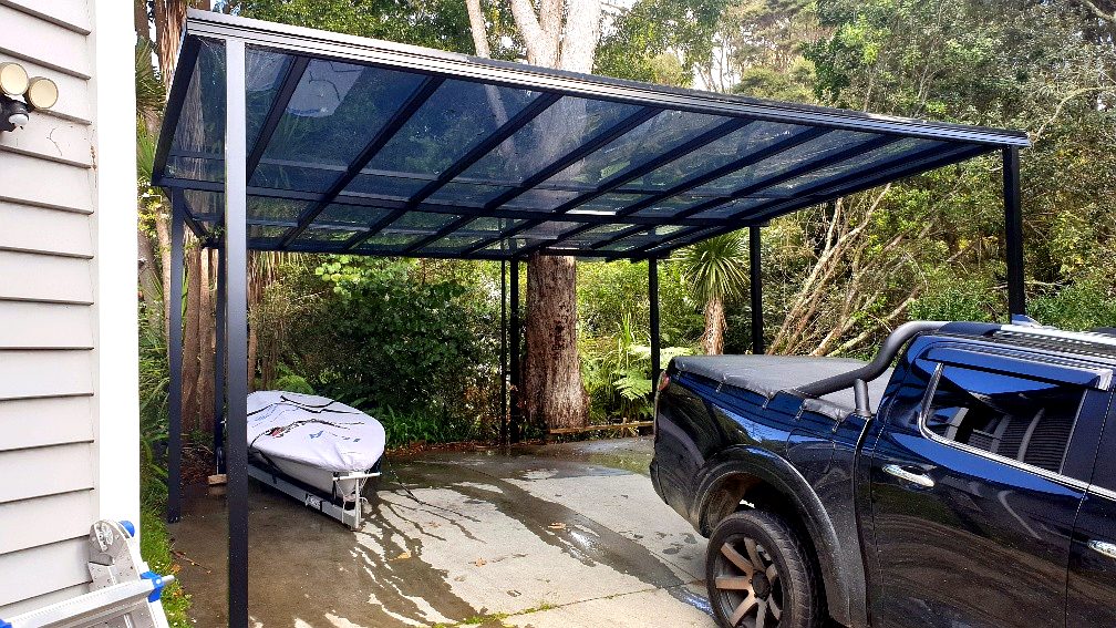 Steel and polycarbonate carport canopy beside a house