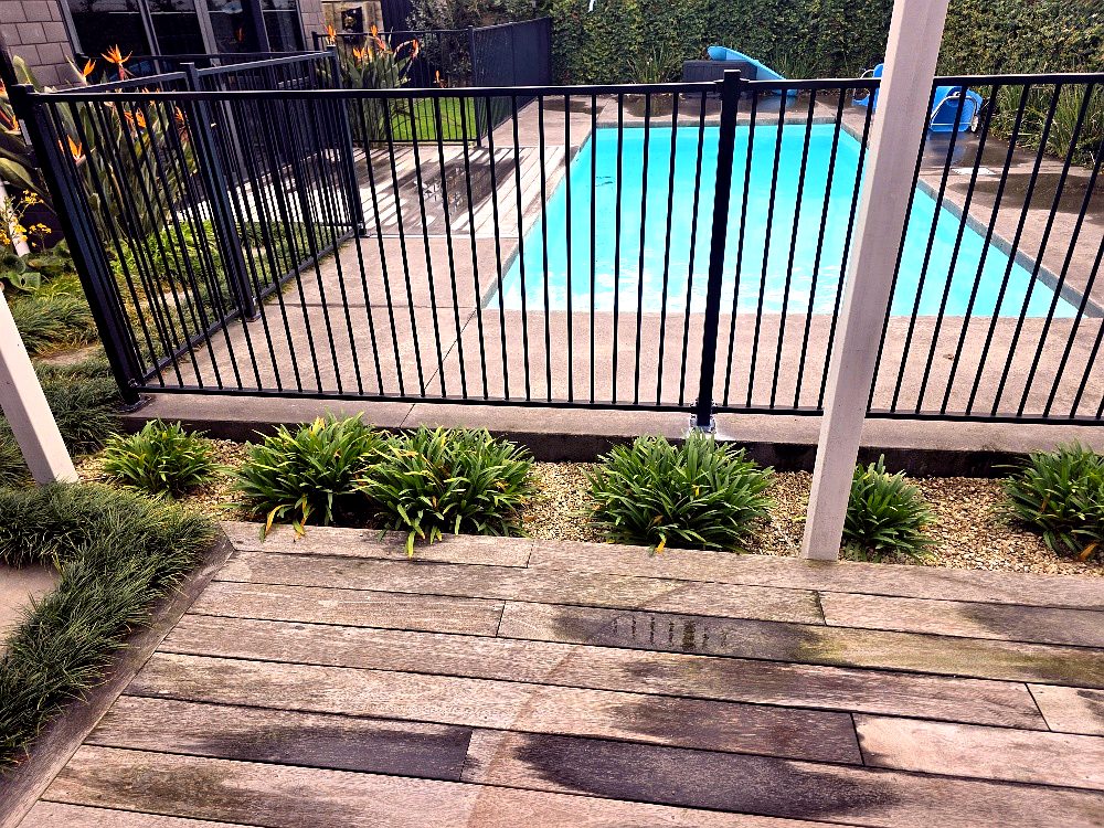 Black aluminium pool fence and timber deck
